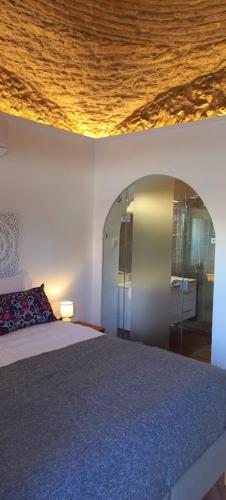 a bedroom with a bed and a ceiling with a mirror at Casa Do Pescador Olhão in Olhão