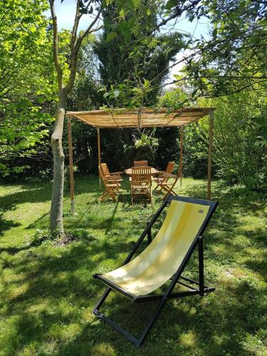 a hammock in a yard with a gazebo at Le Clos de l'Ambre in Divajeu