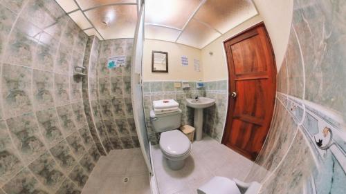 a small bathroom with a toilet and a sink at La Casa de las Flores Hostal in Jardin