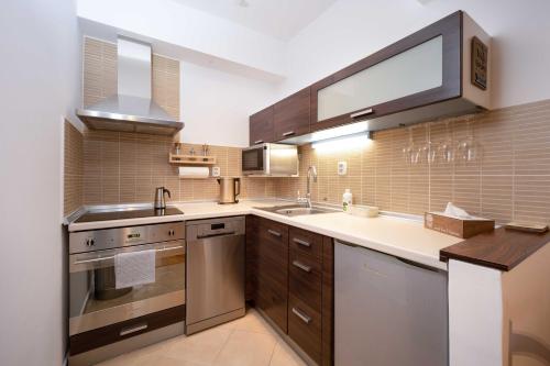 a large kitchen with a sink and a stove at Apartments Tatra Olla - Tatranská Lomnica in Tatranská Lomnica