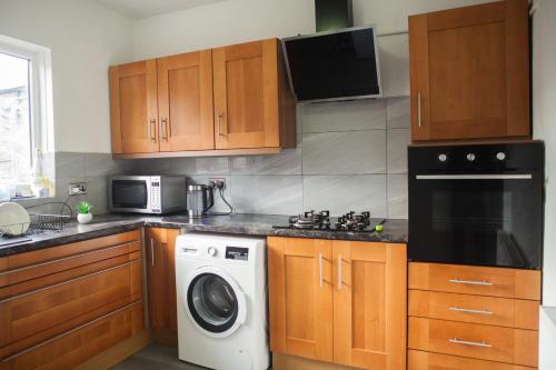 una cucina con lavatrice e forno a microonde di Anfield Apartment a Liverpool