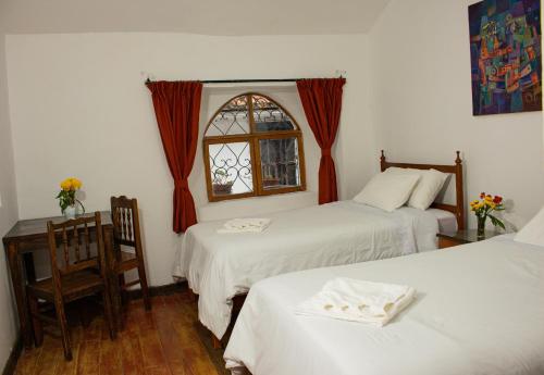 a hotel room with two beds and a window at Posada Catama INN in Cusco