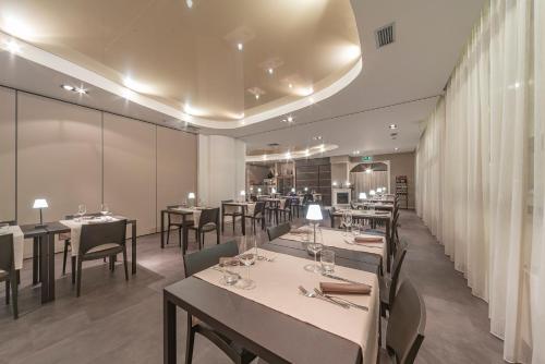 a restaurant with tables and chairs in a room at El Patio Hotel in Corciano