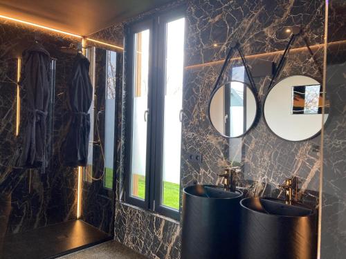 a bathroom with two sinks and two mirrors at Tiny House - Luxury Cottage in Bullange