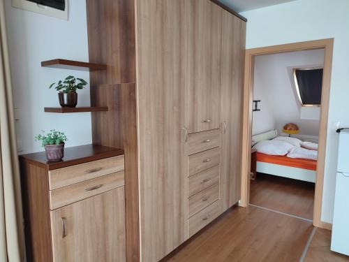 ein Schlafzimmer mit einem großen Holzschrank und einem Bett in der Unterkunft LARIX Apartman in Sárvár