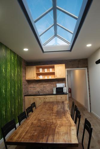 a dining room with a large table and a skylight at Furnas Sweet Home in Furnas