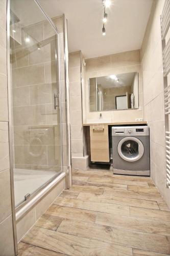 La salle de bains est pourvue d'un lave-linge et d'une douche. dans l'établissement Studio Taormina Valenciennes Centre, à Valenciennes