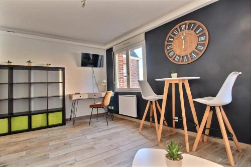 - un salon avec une grande horloge murale dans l'établissement Studio Taormina Valenciennes Centre, à Valenciennes