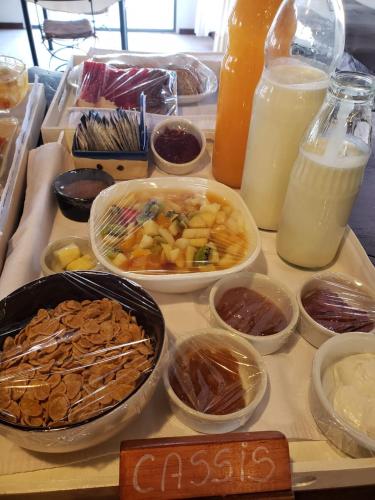 een tafel met kommen eten en flessen melk bij La Quinta Resort in Merlo