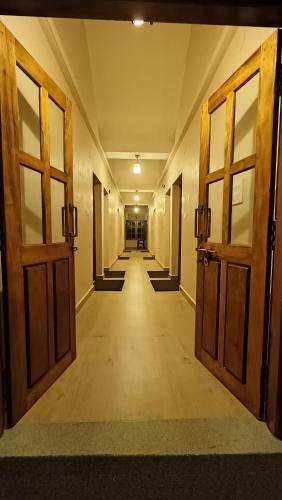 an empty hallway with two doors and a hallway with stairs at OmBodhi Retreat in Kumta