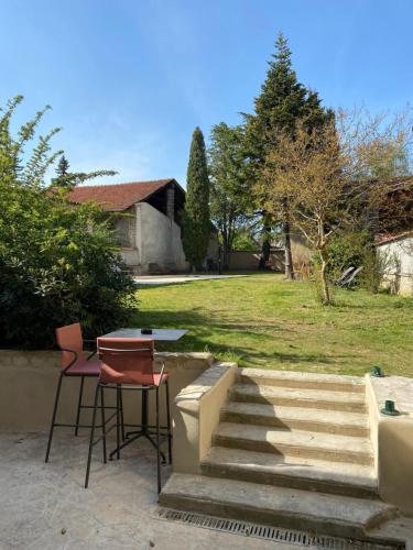 a patio with two chairs and a table and stairs at MY BOUTIQUE GUESTHOUSE - Fabulous Suites 10 Min A7 - in Anneyron