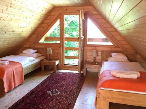 um quarto no sótão com 2 camas e uma janela em Neptun em Międzychód
