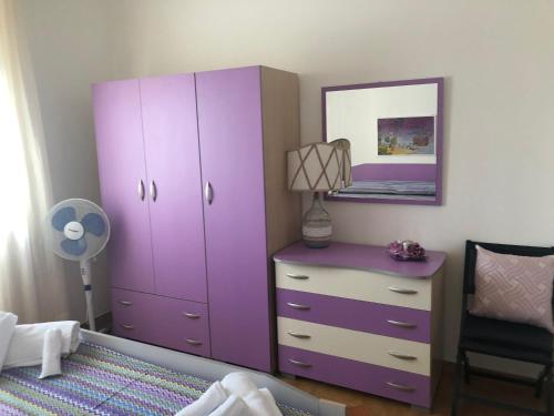 a purple cabinet and a dresser in a bedroom at Sirenetta in Torre Suda