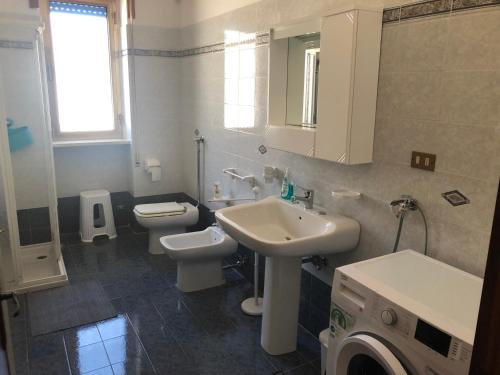 a bathroom with a sink and a toilet and a mirror at Sirenetta in Torre Suda