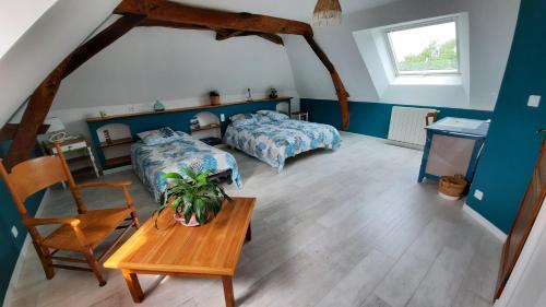 a bedroom with a bed and a table and chairs at La Ménagerie in Maigné
