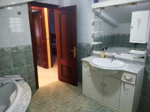 a bathroom with a sink and a toilet and a tub at Apartamento Mar de Fóra in Finisterre