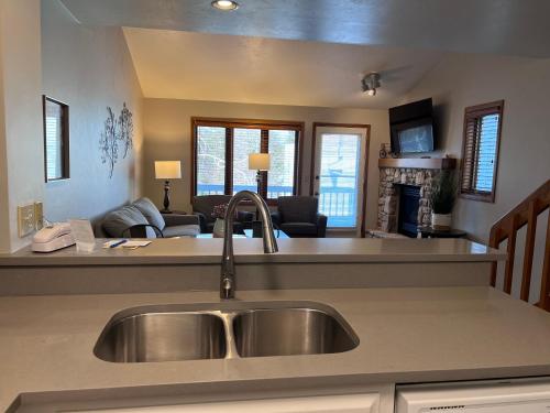 a kitchen with a sink and a living room at Homestead Suites - Fish Creek in Fish Creek