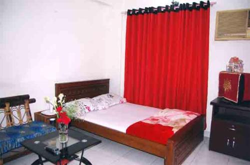 a bedroom with a bed with a red curtain at Marry House in Dhaka