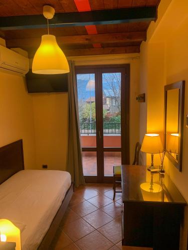 a bedroom with a bed and a desk and a window at Hotel La Locanda Della Franciacorta in Corte Franca