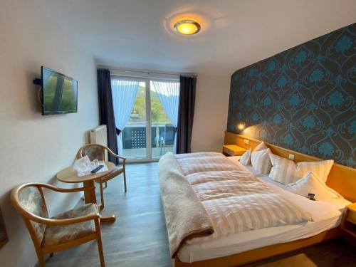 1 dormitorio con 1 cama, 1 mesa y 1 silla en TOP FeWo mit SommerCard, en Winterberg