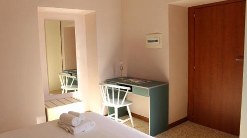 a bedroom with a desk and a bed and a mirror at Ostello Ossigeno in Campodimele