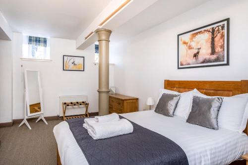 - une chambre avec un grand lit et des draps blancs dans l'établissement The Ness Apartment Highland Club Scotland, à Fort Augustus