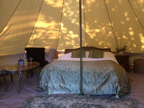 - une chambre avec un lit dans une tente dans l'établissement La Grande Maison, à Pas-de-Jeu