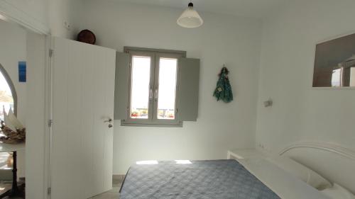 a white room with a tub and a window at Anemomylos Houses in Koufonisia