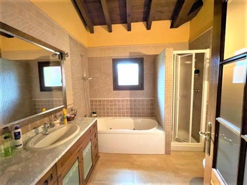 a bathroom with a bath tub and a sink at Villa Doña Perfecta in Guadalix de la Sierra