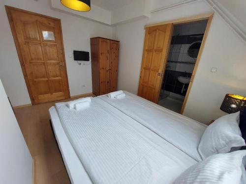 塞格德的住宿－Palma Vendégház，卧室配有一张白色大床和镜子