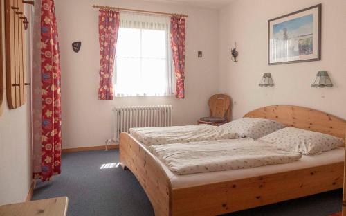 ein Schlafzimmer mit einem Holzbett und einem Fenster in der Unterkunft Ferienhaus Nr 124, Typ A, Feriendorf Hochbergle, Allgäu in Karlsebene
