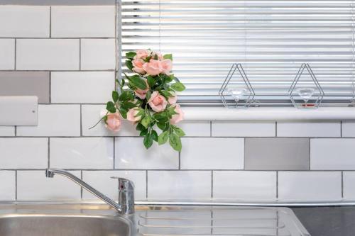 a vase with pink flowers hanging over a sink at Luxury Living - Lovely 1 Bedroom Apartment in Stockton-on-Tees