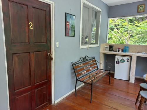 a wooden door with a bench in a room at Donde Familia Manito in Paquera