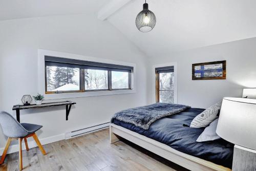- une chambre avec un lit, un bureau et une fenêtre dans l'établissement Chalets Alpins- 08 Chemin Alpin, à Stoneham