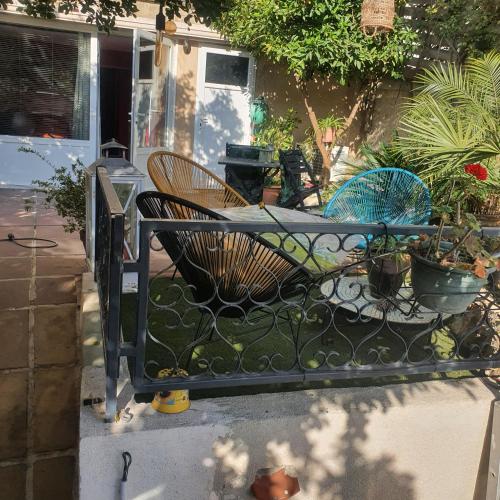 una recinzione di ferro con sedie e piante in un cortile di AndandCo a Marsiglia