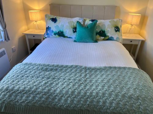 a bed with blue and white pillows and two lamps at Corran, Glenloch View, Fort William 2-Bedroom Loch Side Flat in Fort William