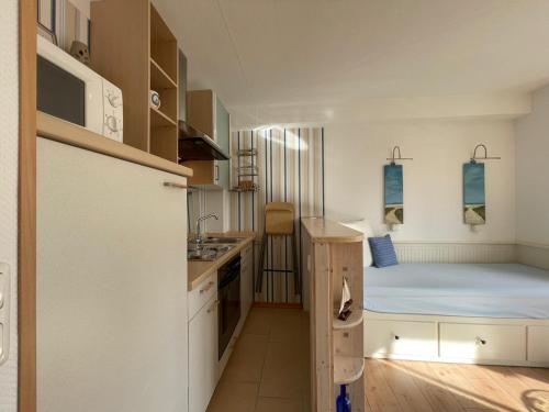 Cette petite chambre comprend un lit et une cuisine. dans l'établissement Ferienappartment am Kurpark. 100m zum Strand., à Ulstrupfeld