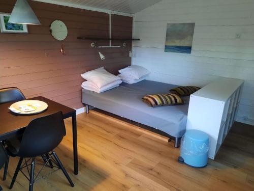 uma pequena cama num quarto com uma mesa e uma mesa gmaxwell gmaxwell gmaxwell gmaxwell em Guldborg Camping & Cottages em Guldborg