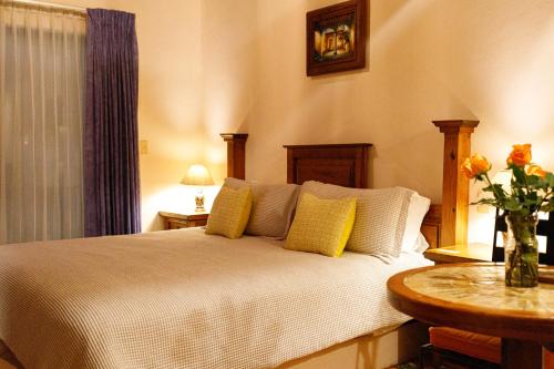 a bedroom with a bed with yellow pillows and a table at Hotel Lunata - 5th Avenue in Playa del Carmen