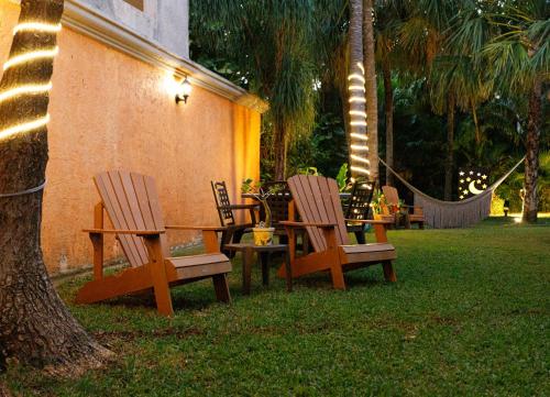 two wooden chairs and a table in a yard at Hotel Lunata - 5th Avenue in Playa del Carmen