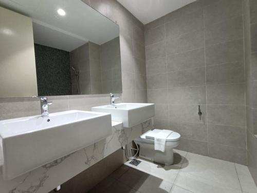 a bathroom with two sinks and a toilet at The Ooak Suites and Residence@ Kiara 163 in Kuala Lumpur