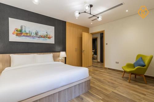een slaapkamer met een groot bed en een groene stoel bij Keysplease Modern 1 BR Beach Apt 07A Murjan 1, JBR in Dubai