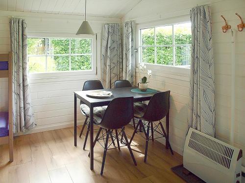 a dining room with a table and four chairs at Guldborg Camping & Cottages in Guldborg