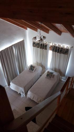 two beds in a room with white curtains at La Liebre in Federación