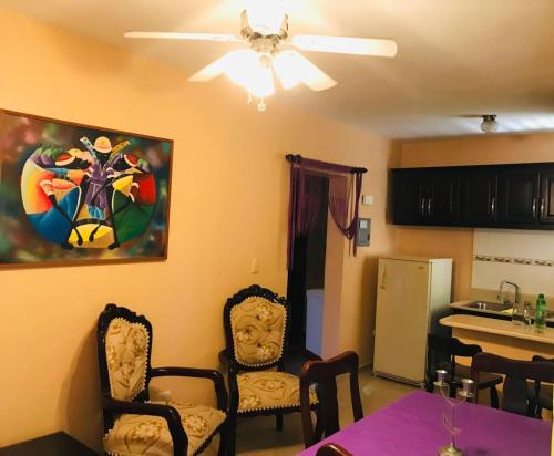 uma sala de estar com uma mesa e cadeiras e uma ventoinha de tecto em APARTAMENTOS IPAP LUPERON em Puerto de Luperon
