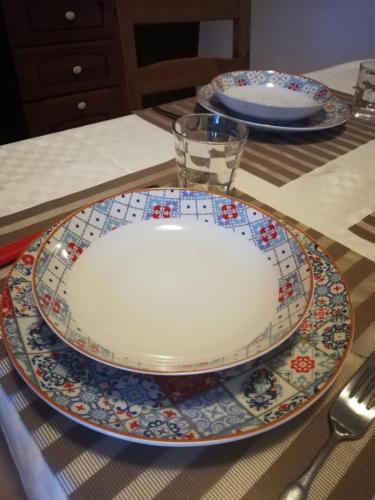 a table with two plates and a glass on it at Monolocale con giardino e parcheggio privato CITRA zero zero ottanta trentuno LT 0281 in Imperia