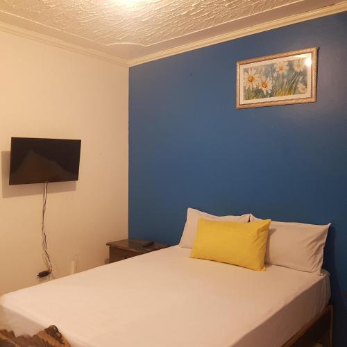 a blue bedroom with a bed with a yellow pillow at The Braemar Suite III New Kingston in Kingston
