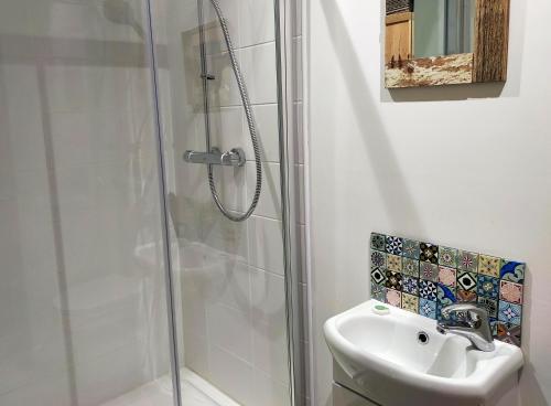 uma casa de banho com um chuveiro e um lavatório. em Seven Bays Stays em Saint Merryn