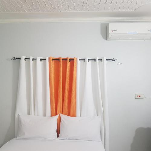 an orange and white curtain in a room with a bed at The Braemar Suite III New Kingston in Kingston