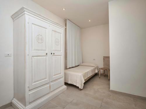 a bedroom with a bed and a white cabinet at Iside Accommodations in Olbia